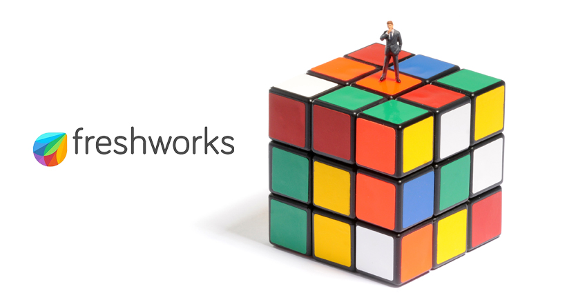 Small figure of businessman standing on Rubik's Cube